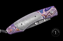 Luxury folding knife with purple and blue marbled handle, textured silver blade, and black braided lanyard, side view, one of a kind
