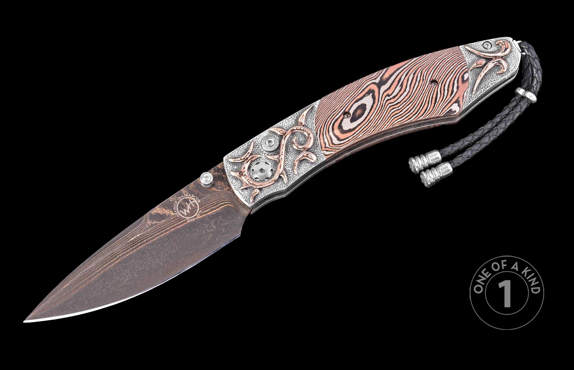 Damascus steel folding knife by W.T. with copper-accented floral inlays, textured handle, and braided black lanyard, side view