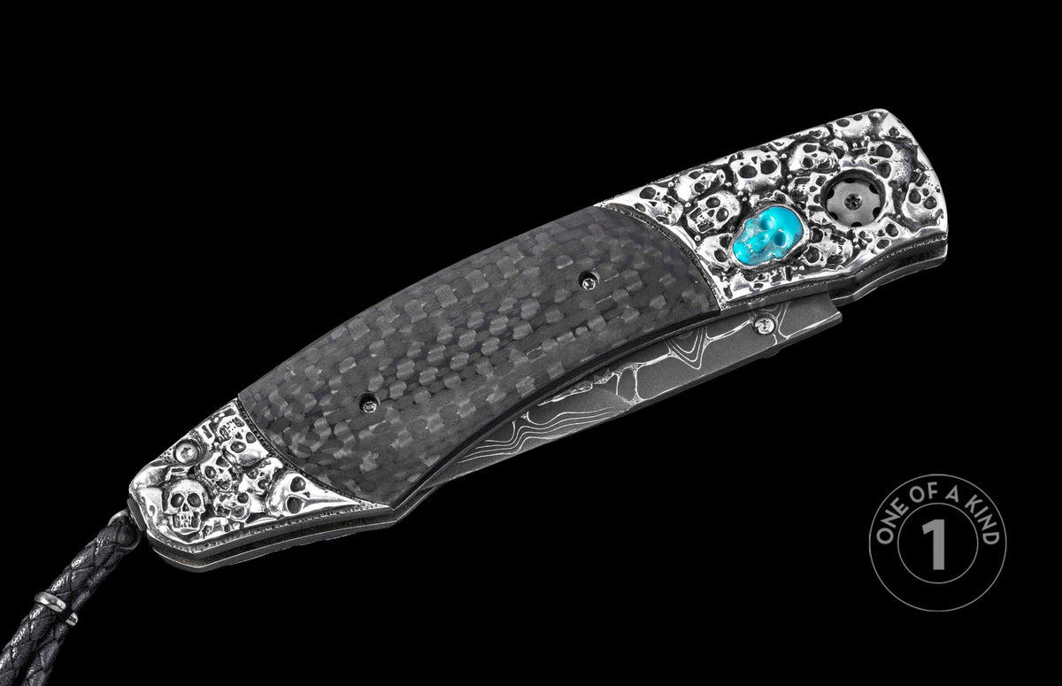 Luxury folding knife with carbon fiber handle and silver skull accents, featuring a turquoise inlay and damascus steel blade, side view.