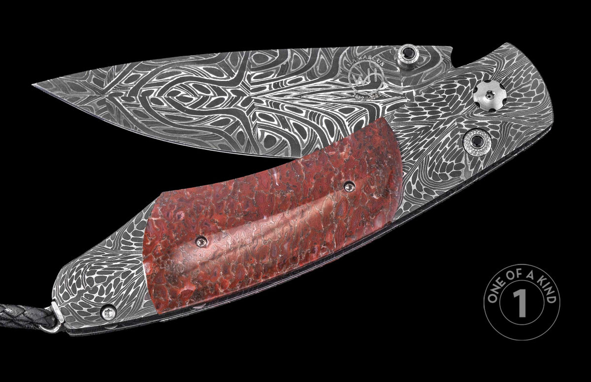 Damascus steel folding knife with red marbled inlay by WH, featuring intricate wave patterns and black gemstone accents, one-of-a-kind design, side view