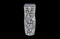 Silver money clip with an etched skull design and ornate scrolling on a textured background.