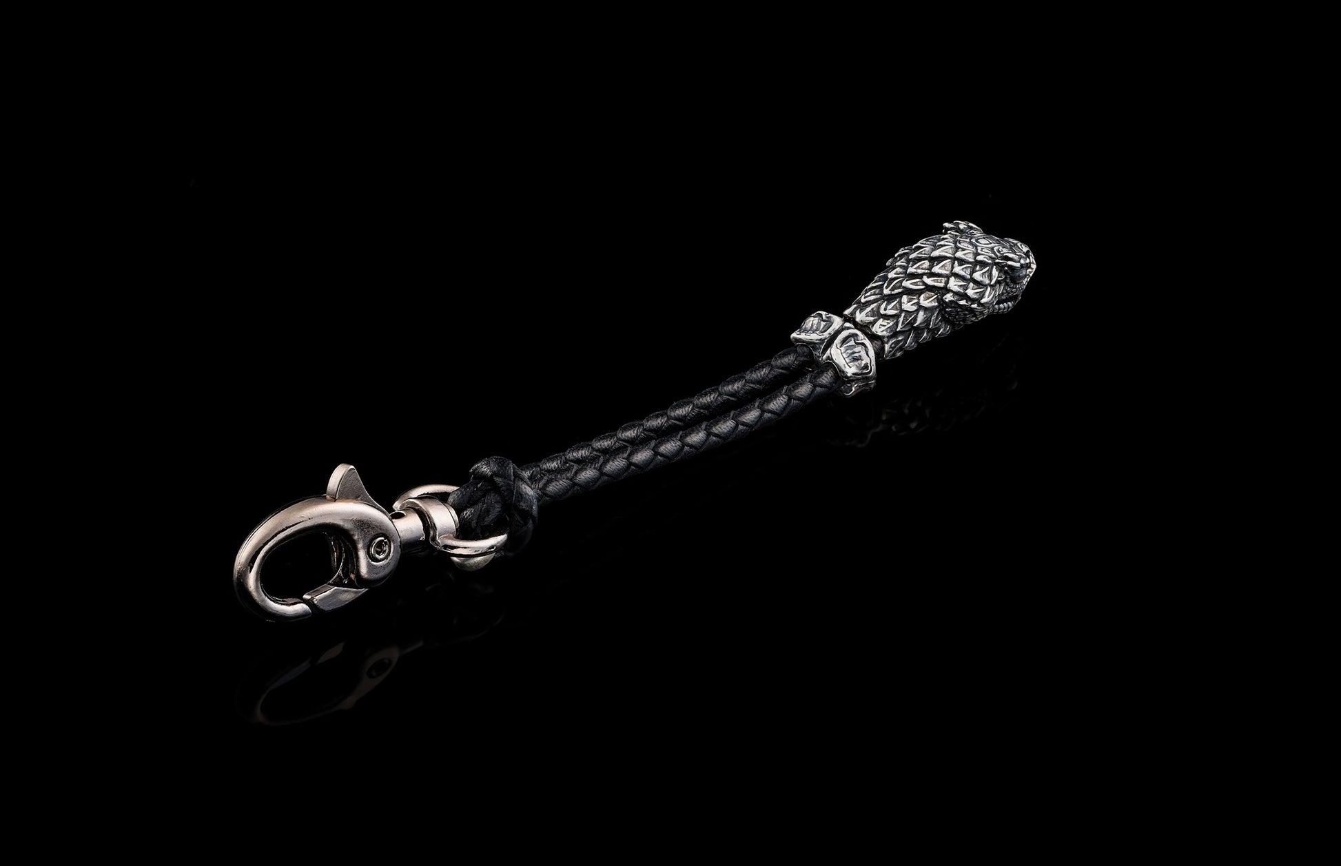 William Henry key fob features a sterling silver snake head and a round-braided black leather cord