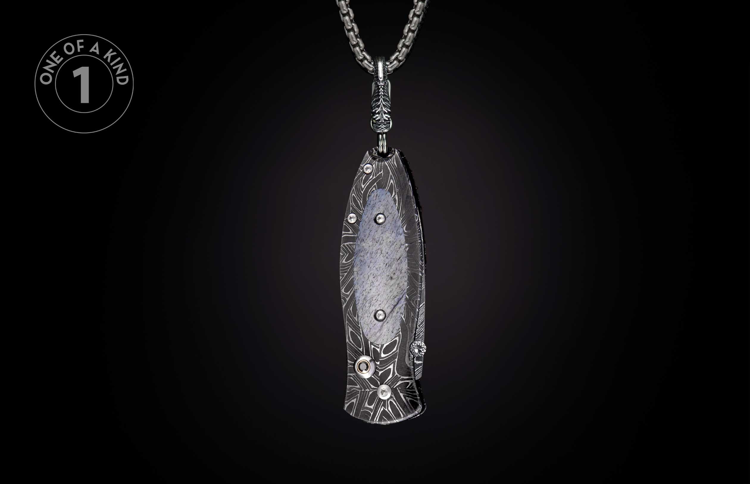 Dark patterned folding knife pendant featuring a gray stone inlay and crystal accents, suspended from a silver chain.