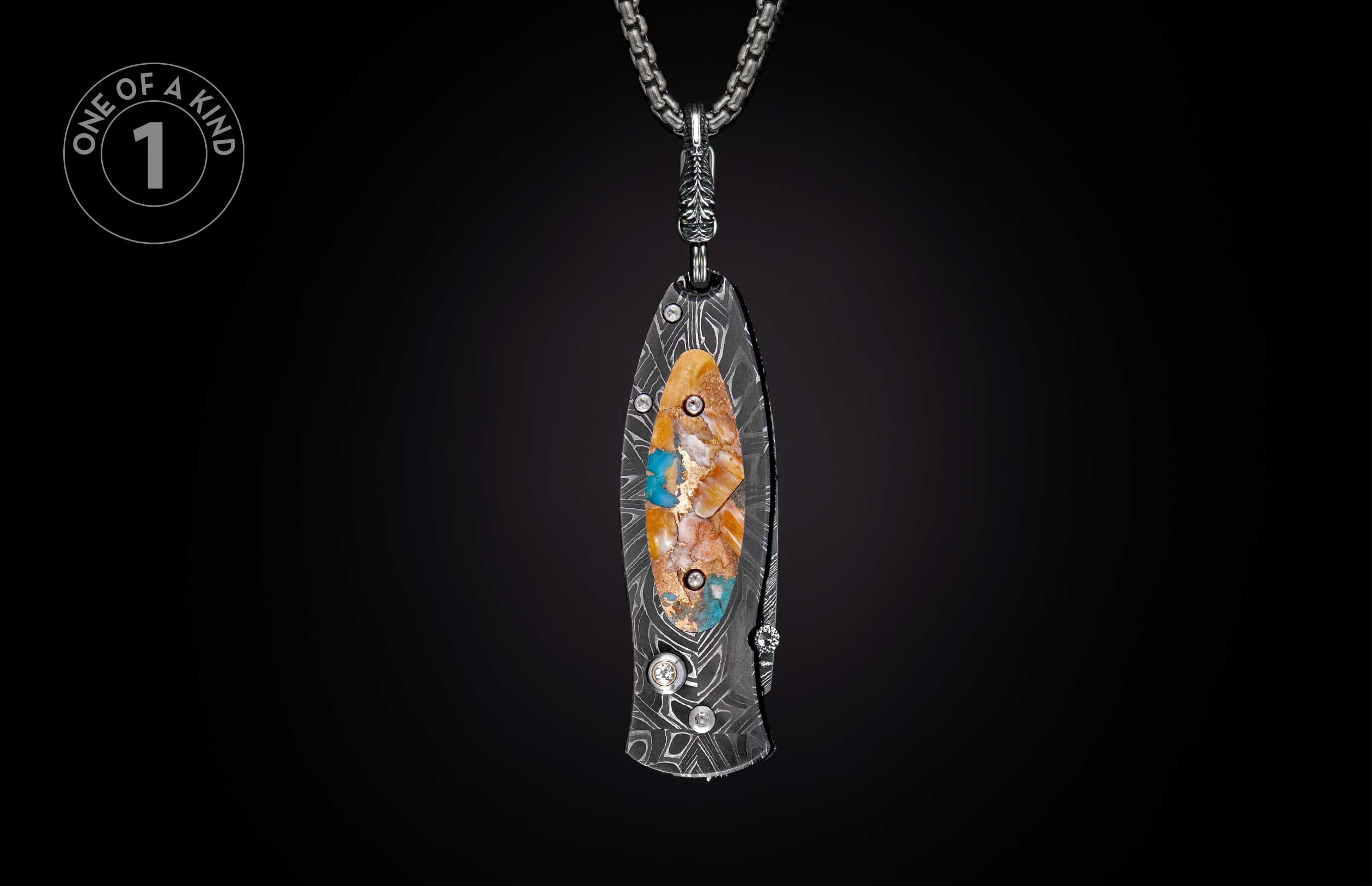 Damascus steel knife with an oval inlay of orange, white, and blue stones with gold flakes, hanging from a silver chain.
