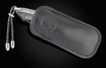 The folding titanium pocket knife with carbon fiber and Damascus steel in a leather case