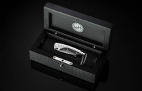 The folding titanium pocket knife with carbon fiber and Damascus steel in a case