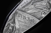 Handcrafted pocket knife from William Henry featuring a stainless steel frame hand-engraved with images of the Statue of Liberty and set with blue sapphires. The blade is hand-forged damascus steel.