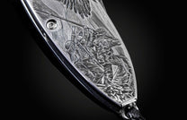 Handcrafted pocket knife from William Henry featuring a stainless steel frame hand-engraved with images of soldiers and set with blue sapphires. The blade is hand-forged damascus steel.
