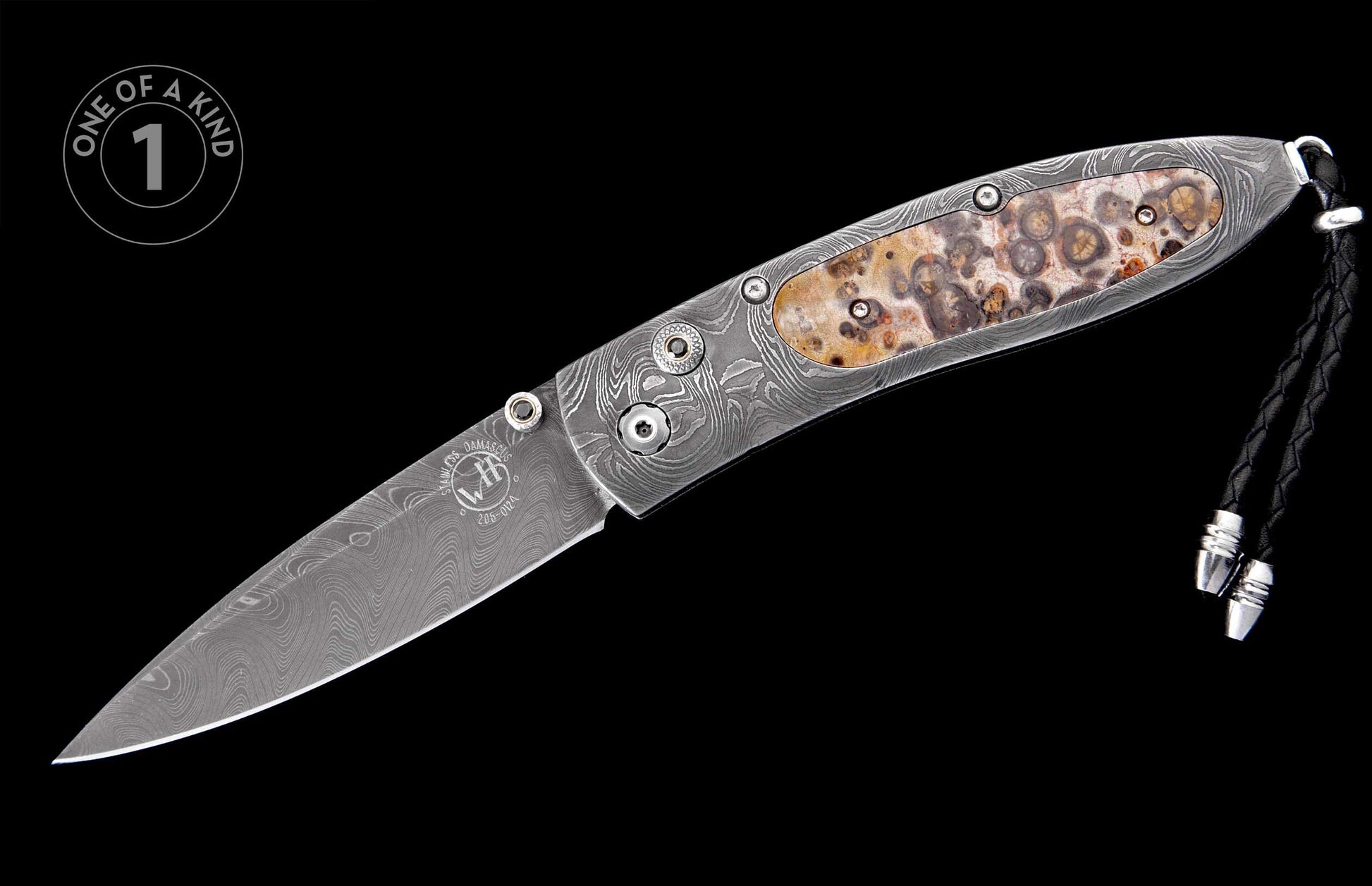 Decorative folding knife with a Damascus blade and handle, featuring a unique spotted stone inlay and a braided black leather lanyard.