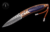 A folding knife with a Damascus blade and ornate handle featuring a blue lapis lazuli inlay, detailed hardware, and a braided brown leather lanyard.