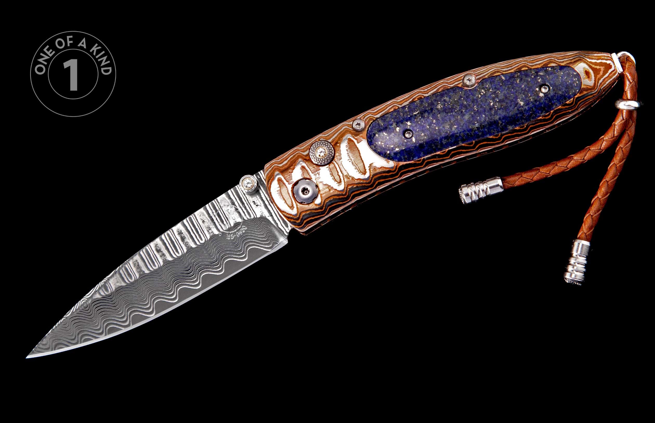 A folding knife with a Damascus blade and ornate handle featuring a blue lapis lazuli inlay, detailed hardware, and a braided brown leather lanyard.