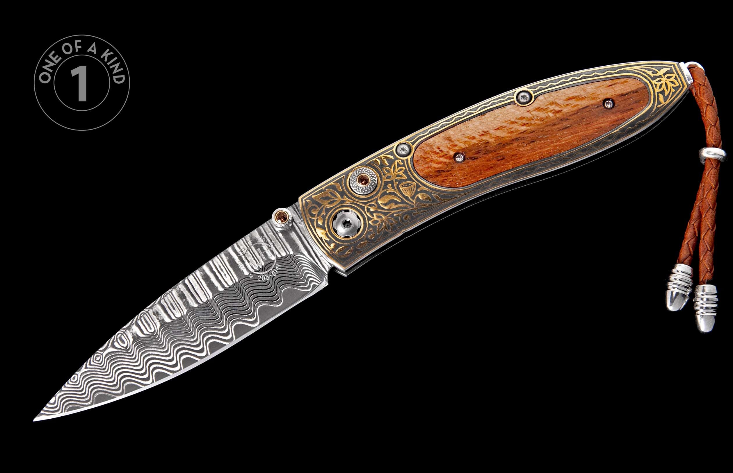 Ornate folding knife with Damascus steel blade, gold engraved handle, wood inlay, and brown leather lanyard.