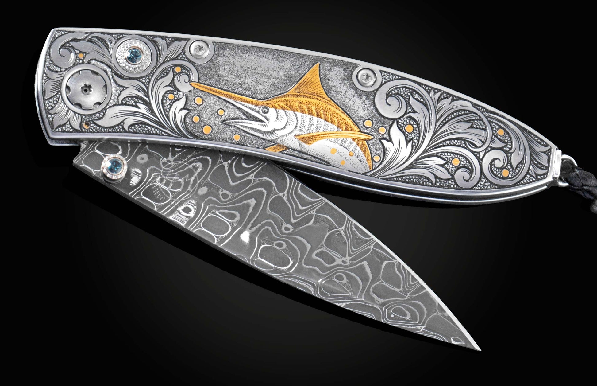 Handcrafted pocket knife from William Henry features a hand-engraved image of a Marlin with 24K gold inlays and set with dark Kashmir blue topaz and a hand forged Damascus steel blade.