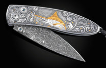 Handcrafted pocket knife from William Henry features a hand-engraved image of a Marlin with 24K gold inlays and set with dark Kashmir blue topaz and a hand forged Damascus steel blade.