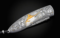 Handcrafted pocket knife from William Henry features a hand-engraved image of a Marlin with 24K gold inlays and set with dark Kashmir blue topaz and a hand forged Damascus steel blade.