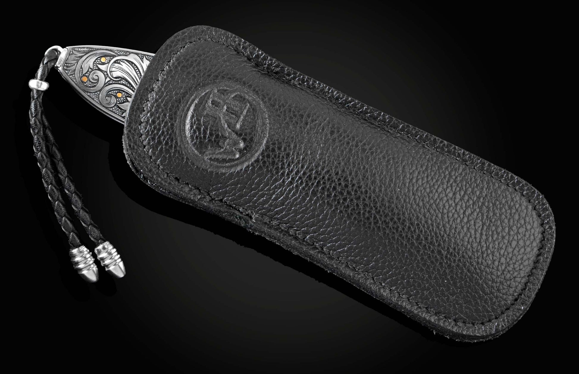 Handcrafted pocket knife from William Henry features a hand-engraved image of a Marlin with 24K gold inlays and set with dark Kashmir blue topaz and a hand forged Damascus steel blade.