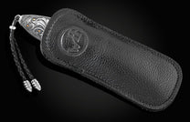 Handcrafted pocket knife from William Henry features a hand-engraved image of a Marlin with 24K gold inlays and set with dark Kashmir blue topaz and a hand forged Damascus steel blade.