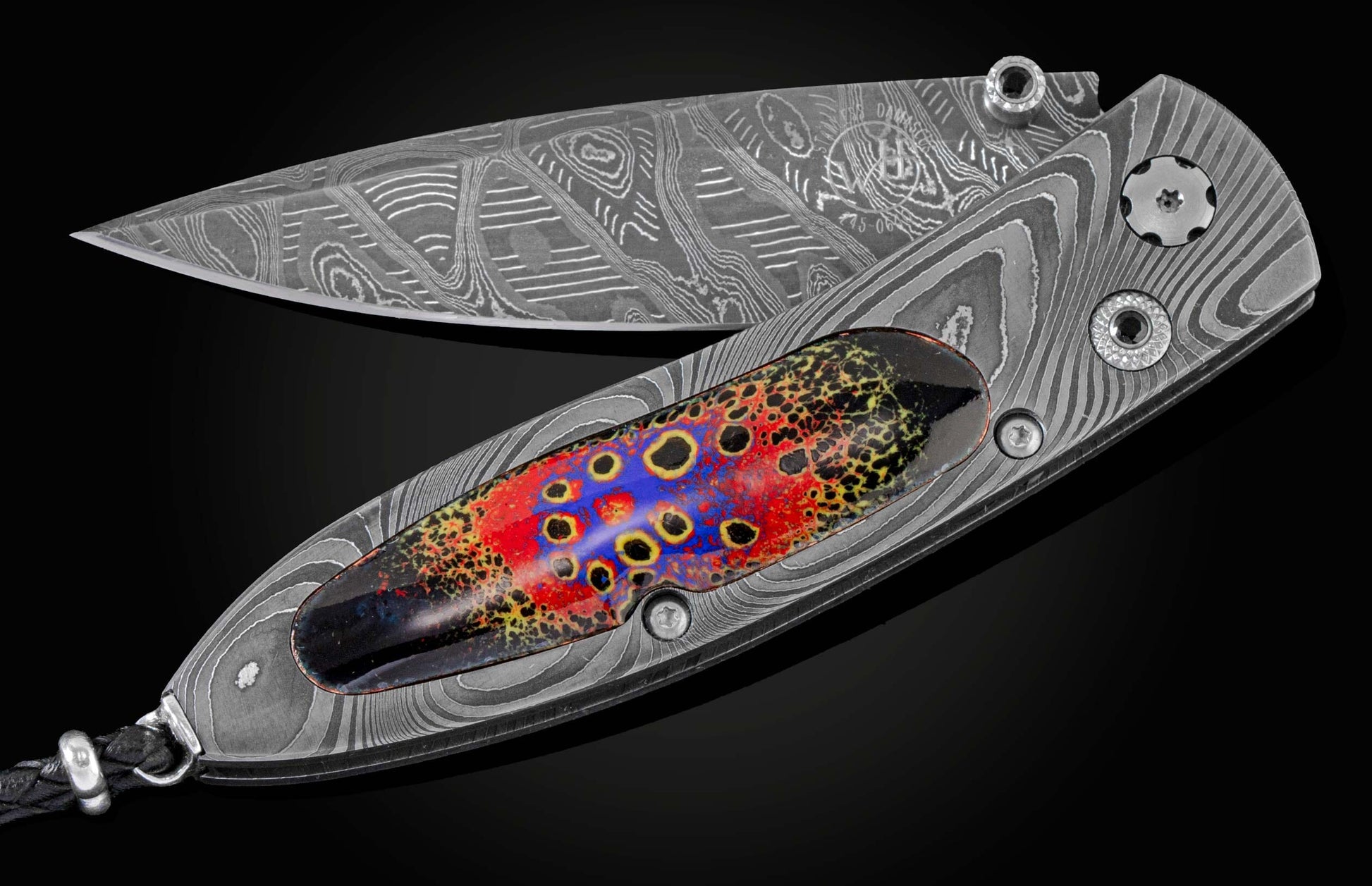 Handcrafted pocket knife from William Henry features a frame in hand-forged Damascus steel, inlaid with enamel artistry by Little Lake Metals. The blade is hand-forged Damascus and the button lock and thumb stud are set with spinel gemstones.