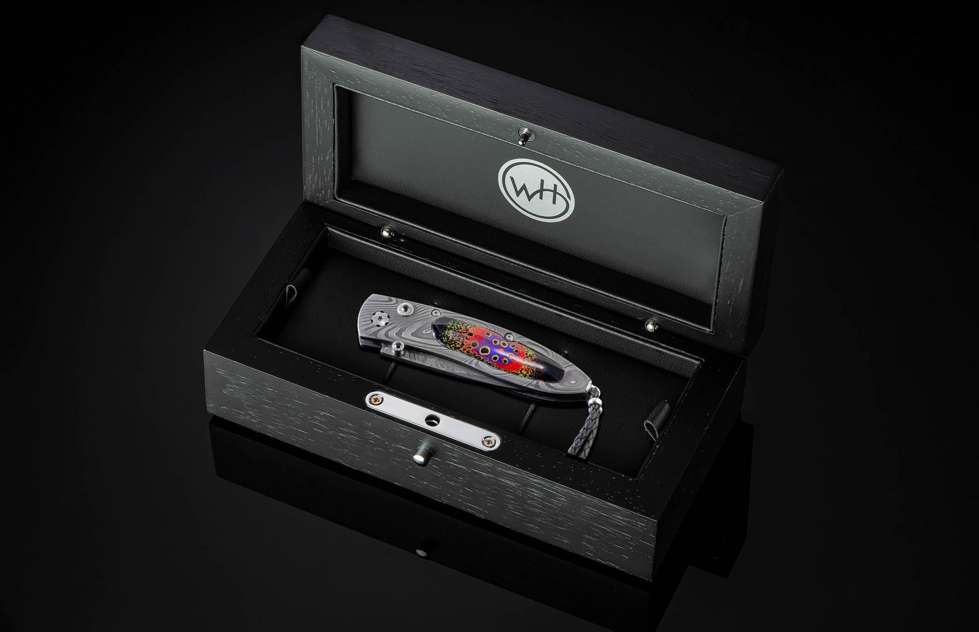  inlaid with enamel artistry by Little Lake Metals. The blade is hand-forged Damascus and the button lock and thumb stud are set with spinel gemstones.