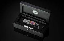  inlaid with enamel artistry by Little Lake Metals. The blade is hand-forged Damascus and the button lock and thumb stud are set with spinel gemstones.
