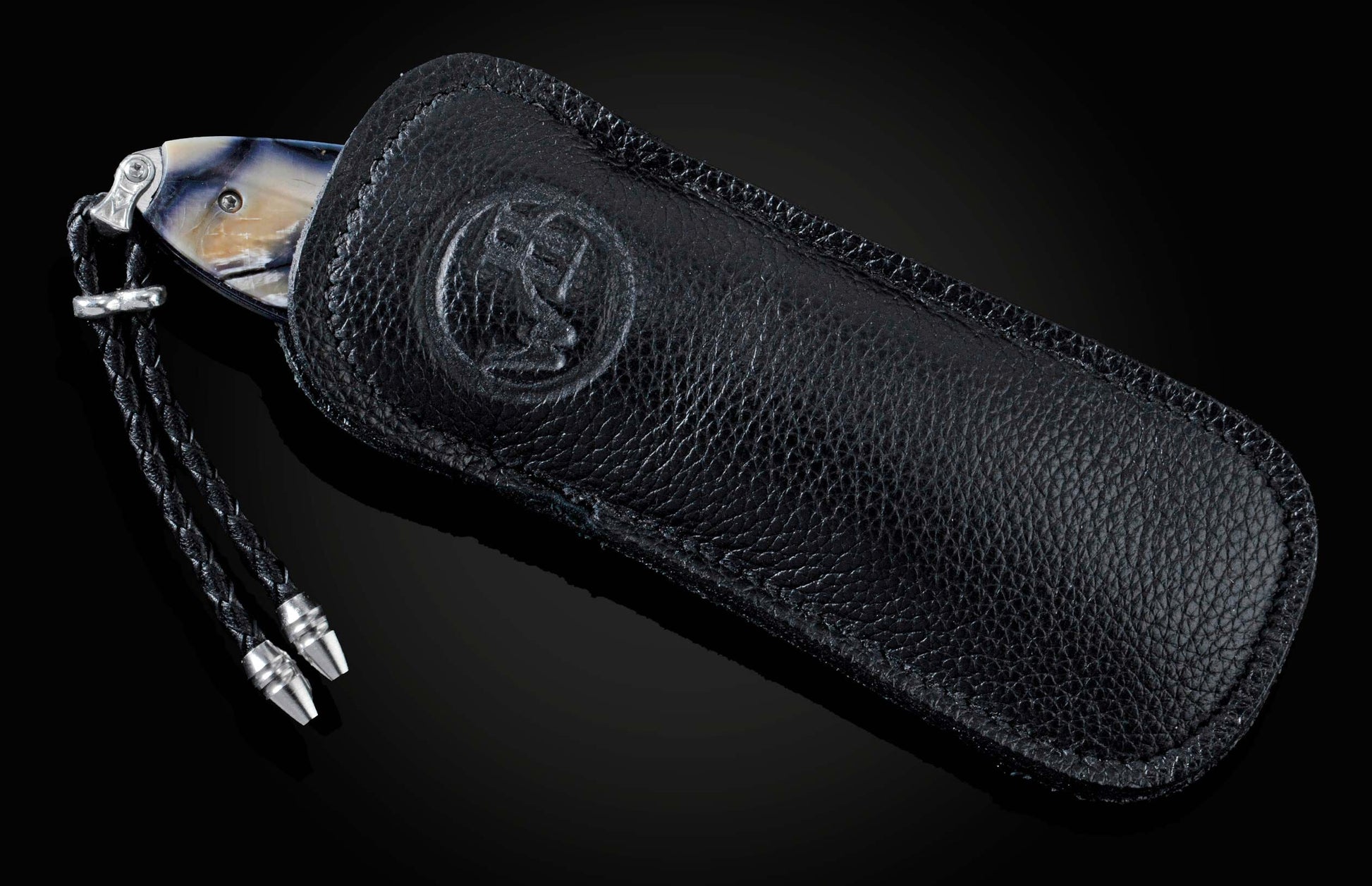 Handcrafted pocket knife from William Henry features a hand-engraved skull and intricate designs with 24K gold inlaid with fossil Woolly Mammoth tusk and set with spinel gemstones. The blade is damascus steel.
