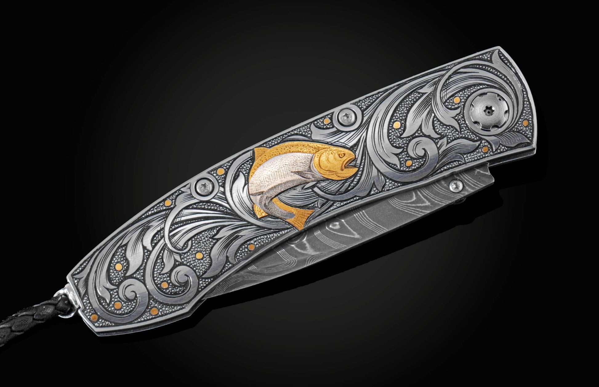 Hand forged Damascus steel blade pocket knife from William Henry. The knife is hand-engraved handle with 24K gold inlays depicting a floral design and a fly fishing lure. The knife is displayed closed on a black background.