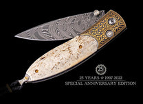Folding knife with a swirling Damascus steel blade, mottled bone handle, and ornate gold bolster inlaid with clear gems.