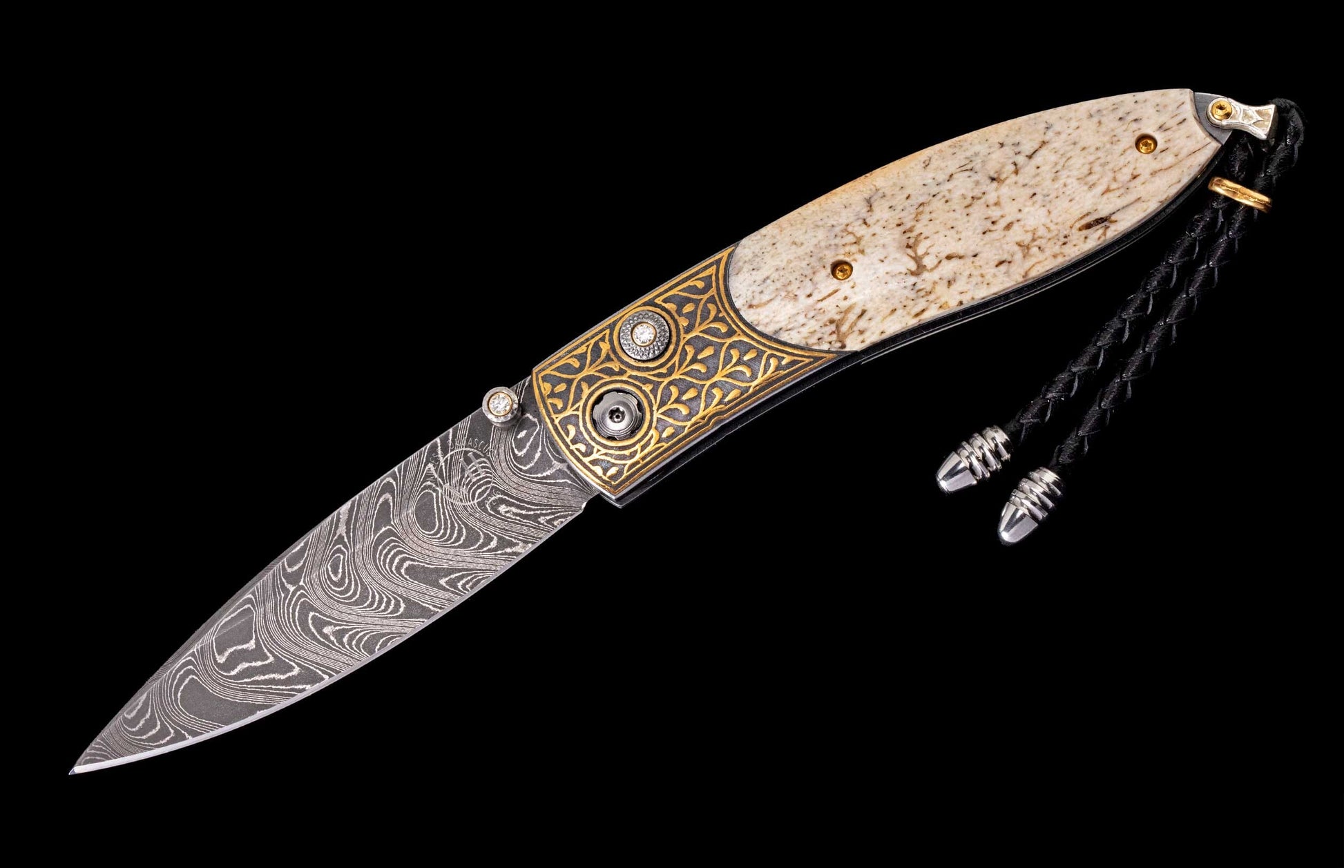 Ornate open folding knife with swirling Damascus blade, gold filigree, natural bone handle, diamond accents, and braided lanyard.