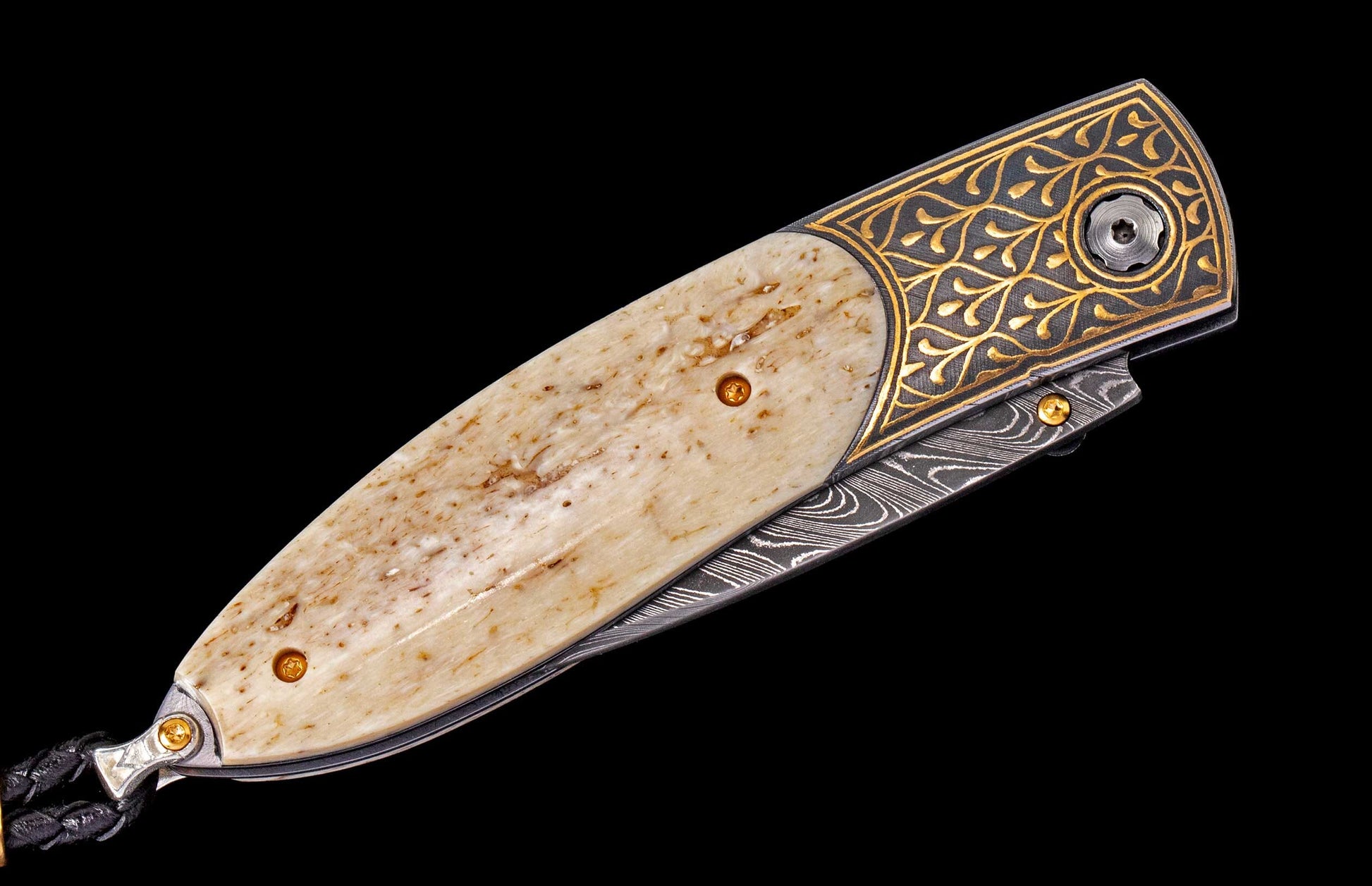 Custom folding knife featuring a light bone handle, gold engraved dark metal, and patterned Damascus steel blade.