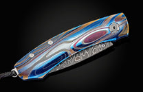 Handcrafted William Henry knife featuring anodized blue and laser engraved titanium frame