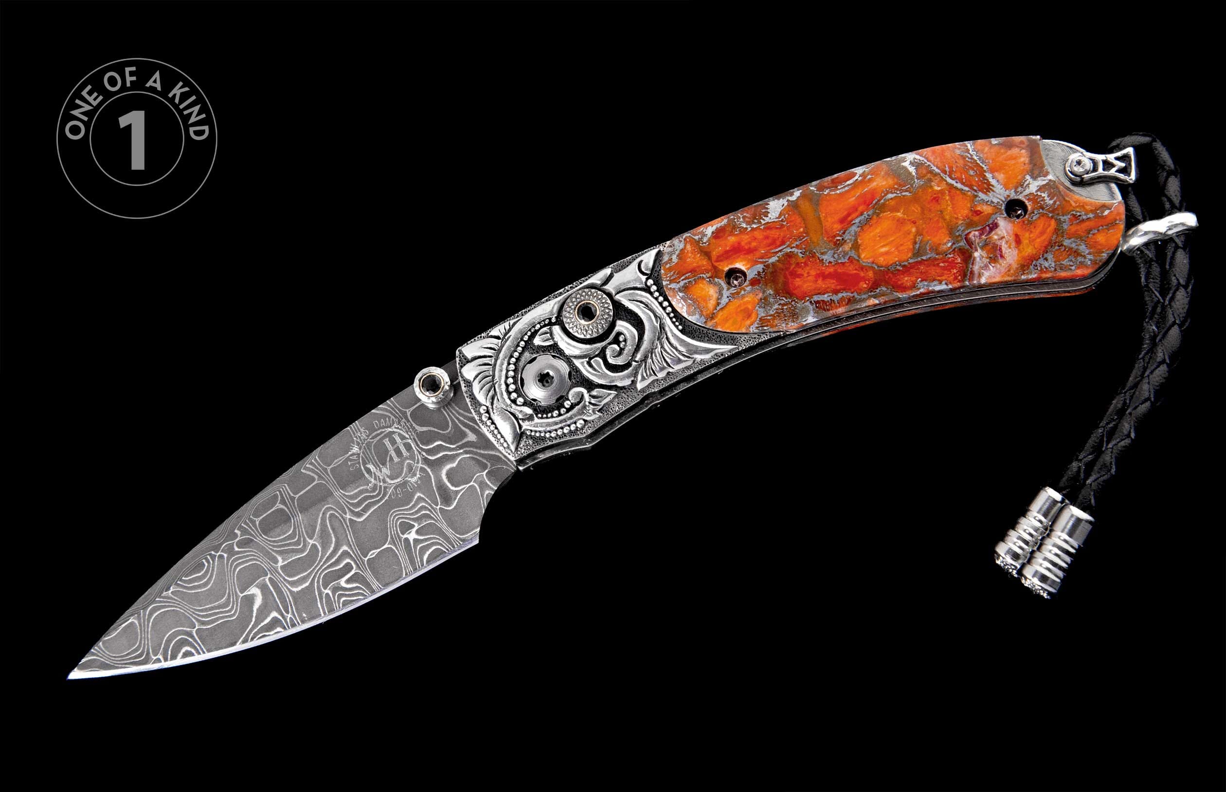 Folding knife with a Damascus blade, intricately engraved silver handle, and marbled orange scales, completed with a black leather lanyard.