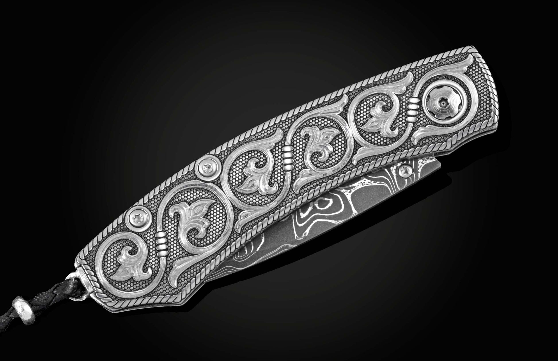 Handcrafted pocket knife from William Henry features hand and laser engraved handles set with sapphire gemstones and a blade of hand-forged Damascus steel.