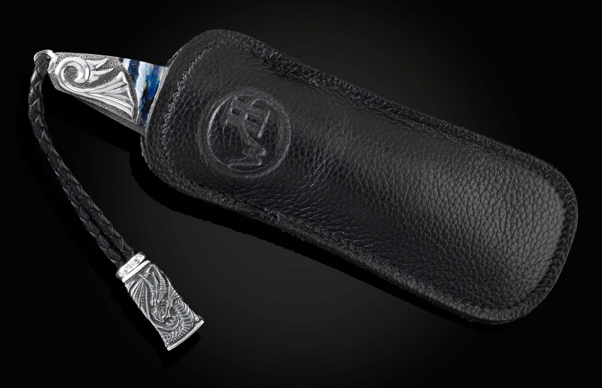 Handcrafted pocket knife from William Henry features a hand-carved sterling silver depicting a dragons head and tail