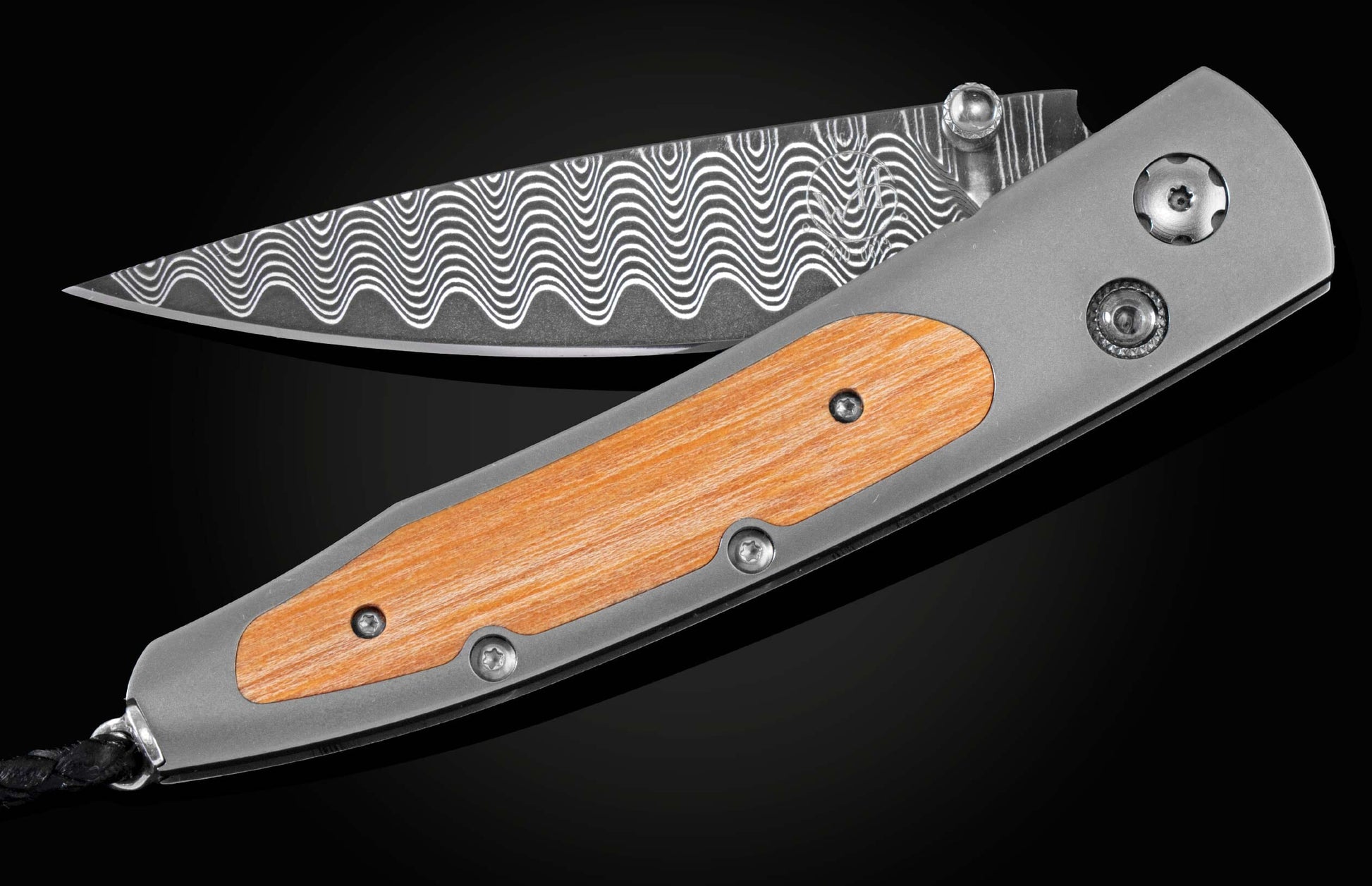 Handcrafted pocket knife from William Henry featuring a titanium frame inlaid with wood from Autzen Stadium, white topaz gemstones, and a hand forged Damascus steel blade.