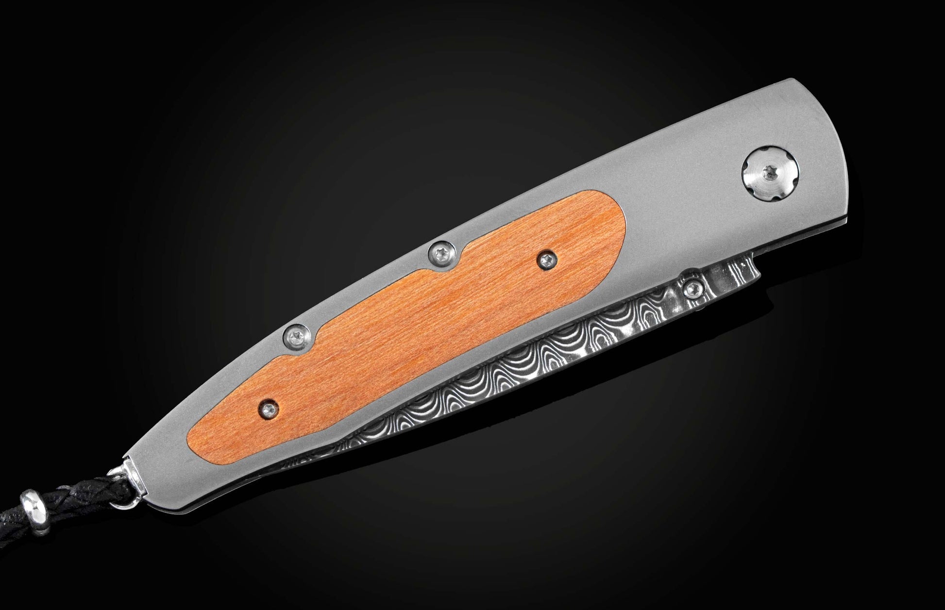 Handcrafted pocket knife from William Henry featuring a titanium frame inlaid with wood from Autzen Stadium