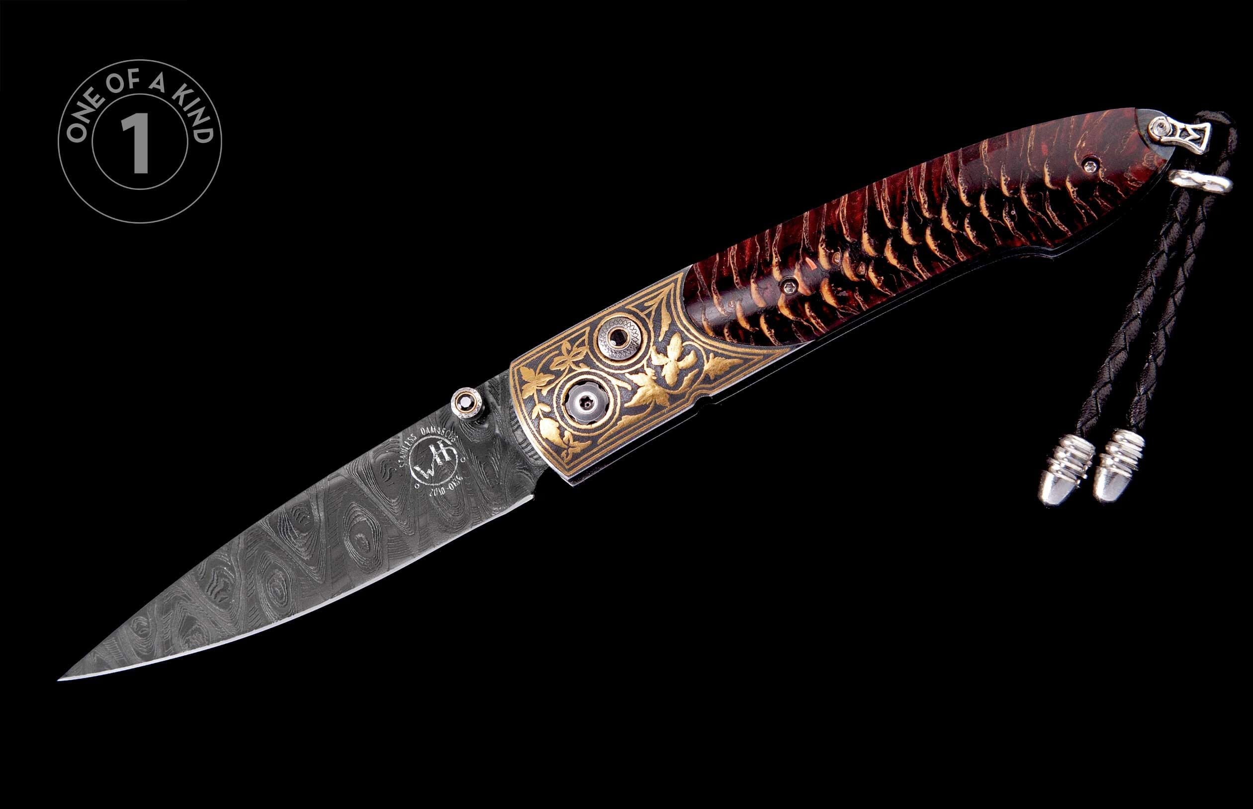 Folding knife with a Damascus steel blade featuring a 'WH' logo, ornate gold filigree, a reddish-brown scaled handle, and a braided black cord.