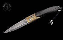 Luxury folding knife with a wavy Damascus blade, carbon fiber handle, ornate gold accents, and a braided lanyard.
