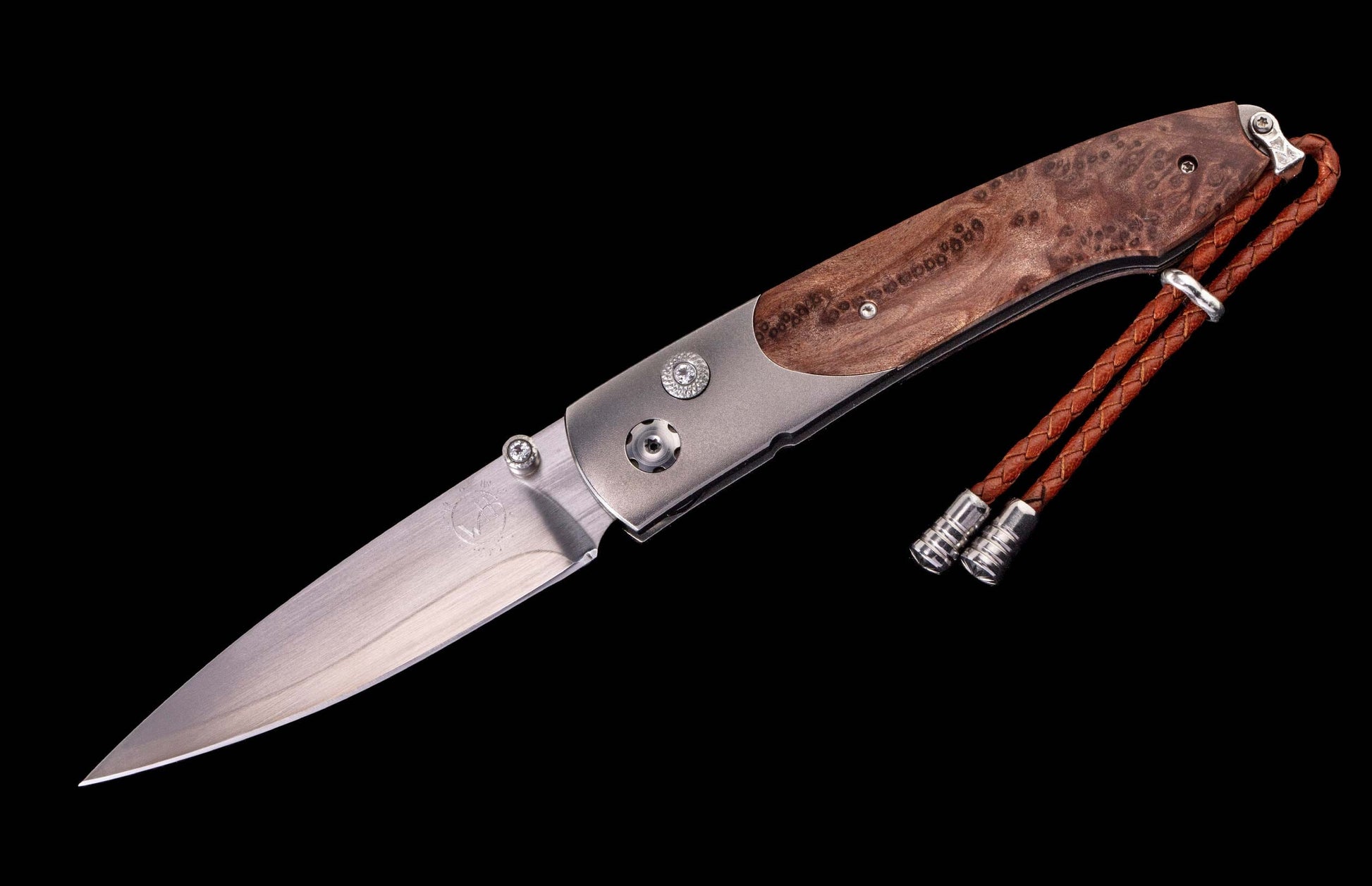 Silver blade knife with dark brown burled wood and brushed silver handle, featuring a brown braided leather lanyard.