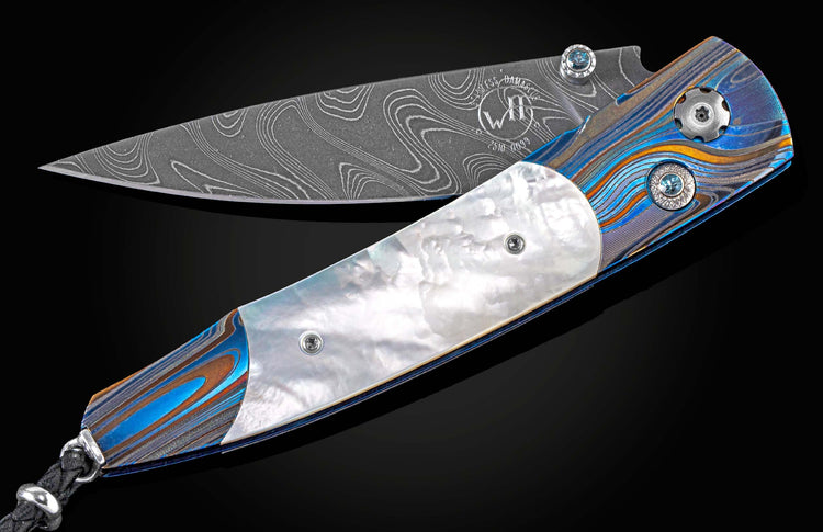 Exclusive edition knife from William Henry with a 'Laser Blue' finished frame in aerospace grade titanium, mother of pearl scales, London Blue topaz and a hand-forged damascus steel blade by Chad Nichols