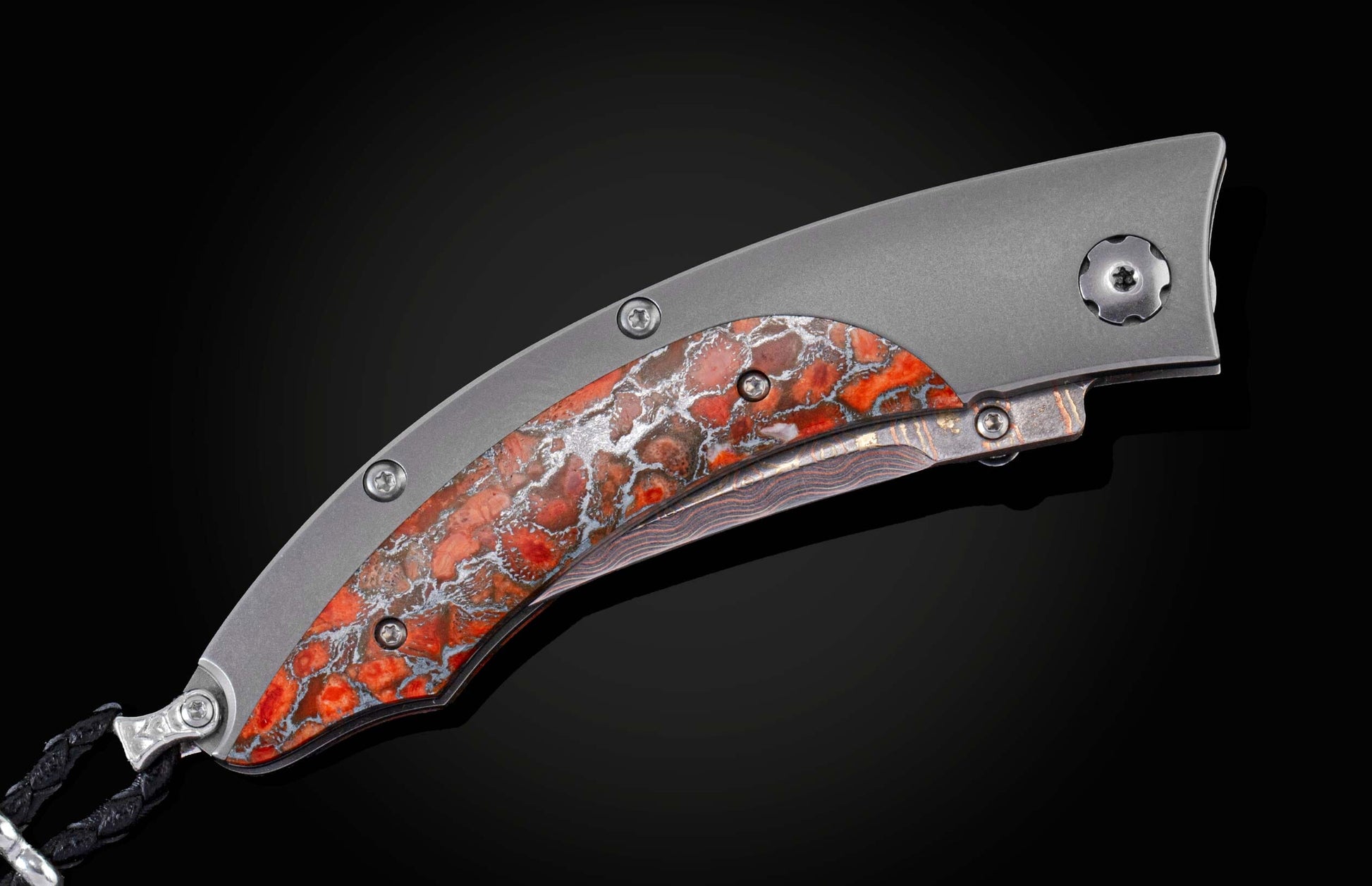 Handcrafted pocket knife from William Henry features a titanium frame inlaid with orange and red zinc matrix Apple Coral. The button lock and the thumb stud have been set with citrine gemstones and the hand forged Damascus steel blade has a copper wave pa