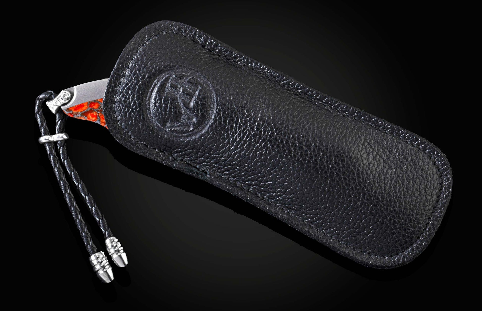 Handcrafted pocket knife from William Henry features a titanium frame inlaid with orange and red zinc matrix Apple Coral. The button lock and the thumb stud have been set with citrine gemstones and the hand forged Damascus steel blade has a copper wave pa