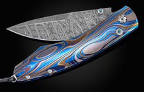 Custom knife from William Henry features a color laser-engraved titanium frame, London Blue topaz gemstones, and a hand-forged damascus steel blade by Mike Norris