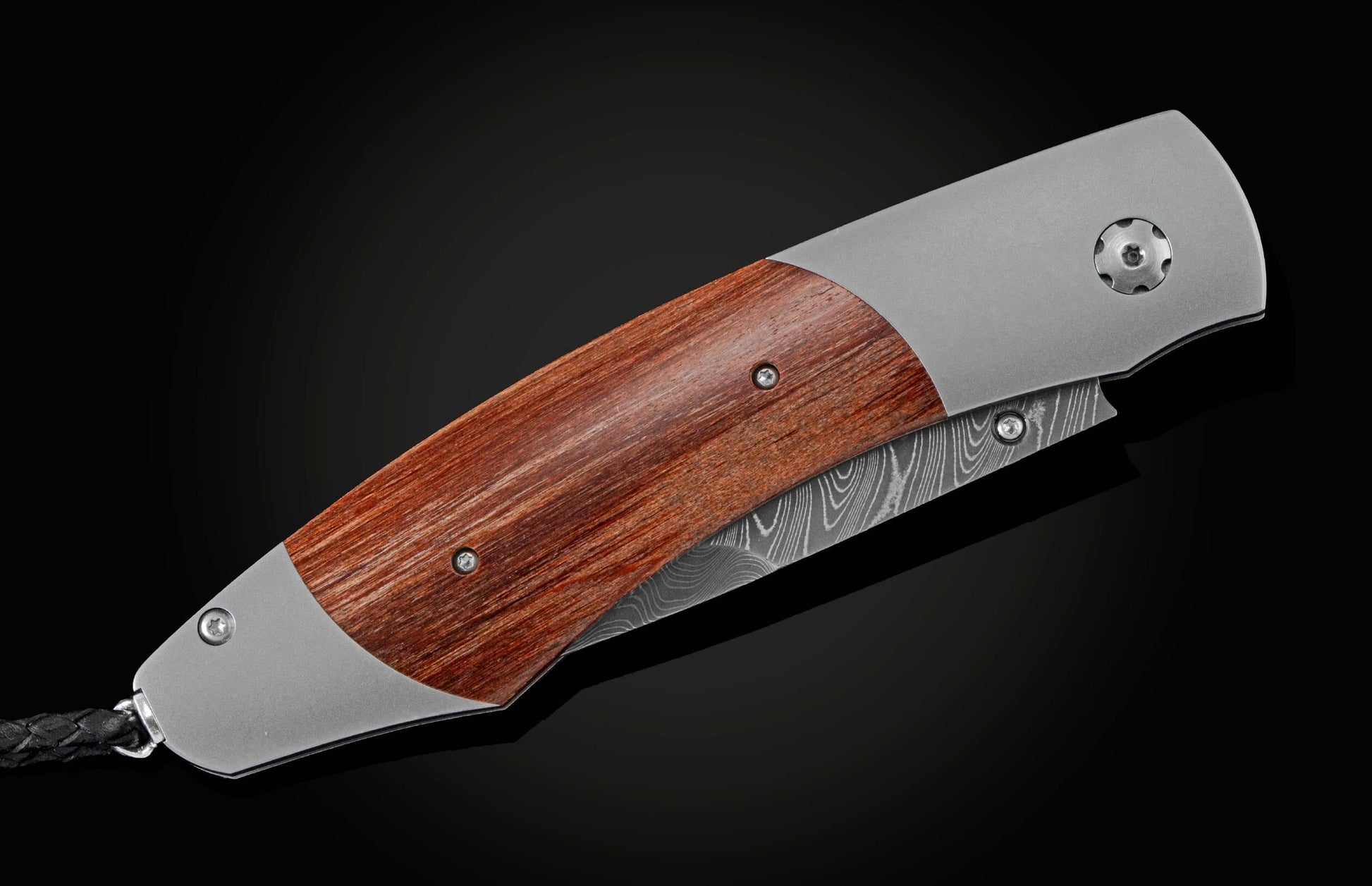  inlaid with reclaimed wood from the seats of Ohio Stadium. The blade is hand-forged Damascus steel and the button lock and the thumb stud are set with rubies. The knife is shown part