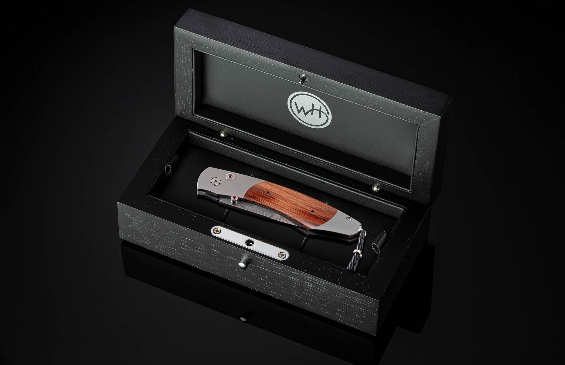  inlaid with reclaimed wood from the seats of Ohio Stadium. The blade is hand-forged Damascus steel and the button lock and the thumb stud are set with rubies. The knife is shown open