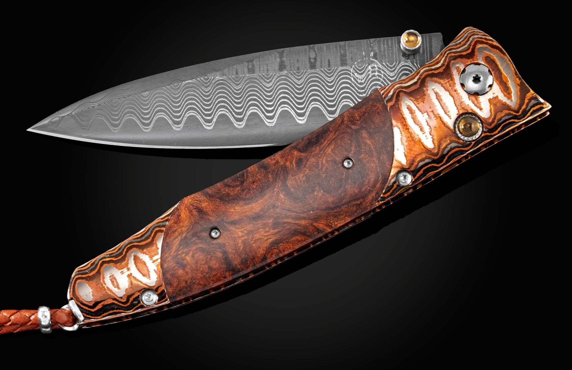 Handcrafted pocket knife from William Henry features a beautiful frame in heat-colored 'Wave Mokume', inlaid with Desert Ironwood, set with citrines, and a hand forged Damascus steel blade.