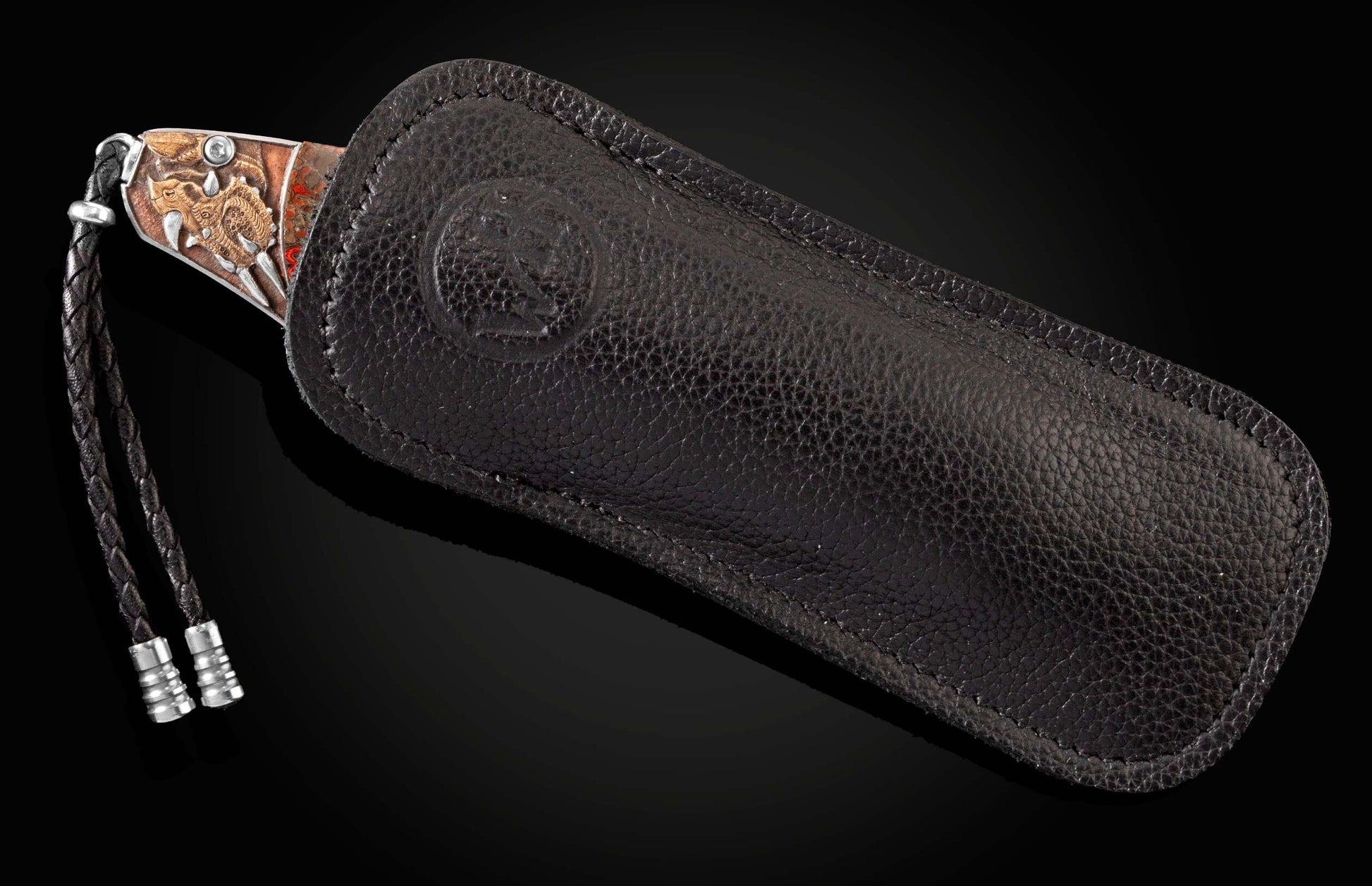 Handcrafted pocket knife from William Henry features hand-engraved images of dinosaurs with copper
