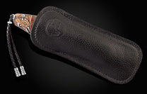 Handcrafted pocket knife from William Henry features hand-engraved images of dinosaurs with copper