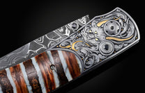 Custom folding knife with a Damascus blade and engraved metal handle featuring a dragon design and unique banded fossilized scales.