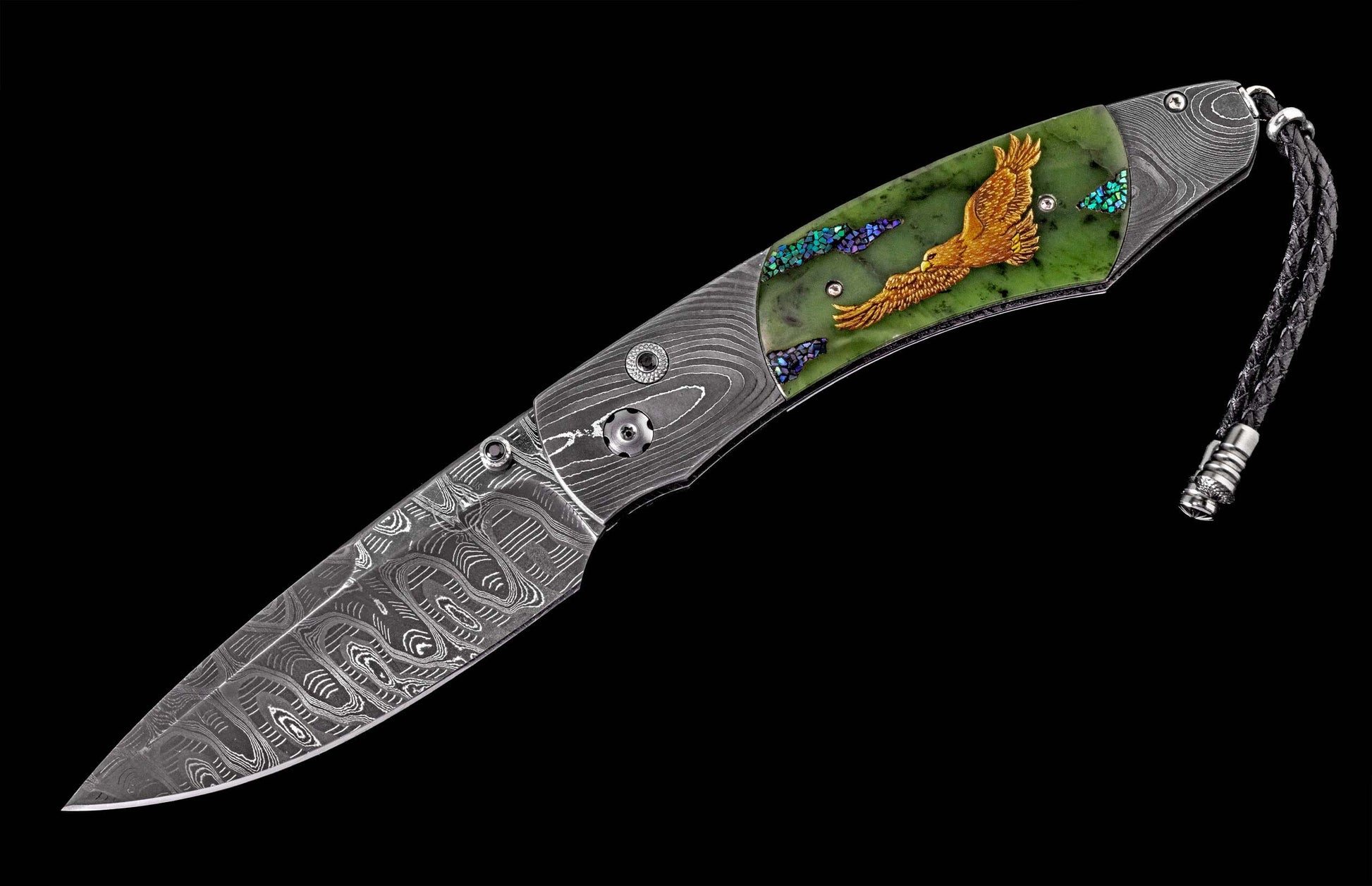 Ornate folding knife with a Damascus steel blade, green stone handle featuring a gold eagle, iridescent accents, and a braided leather lanyard.