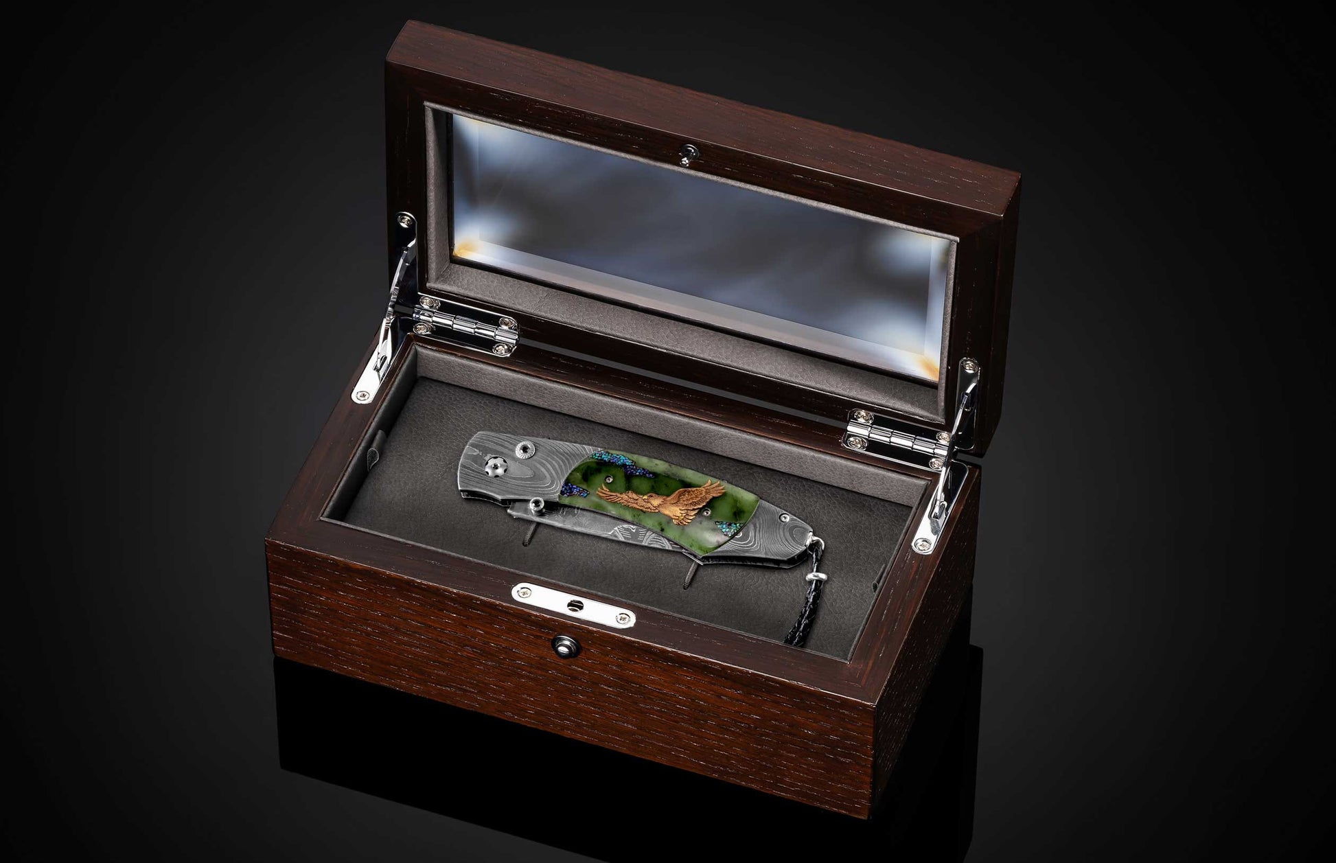 B12 Eagle II folding knife with a Damascus blade, green jade handle featuring a golden eagle inlay and blue accents, in an open wood display box.